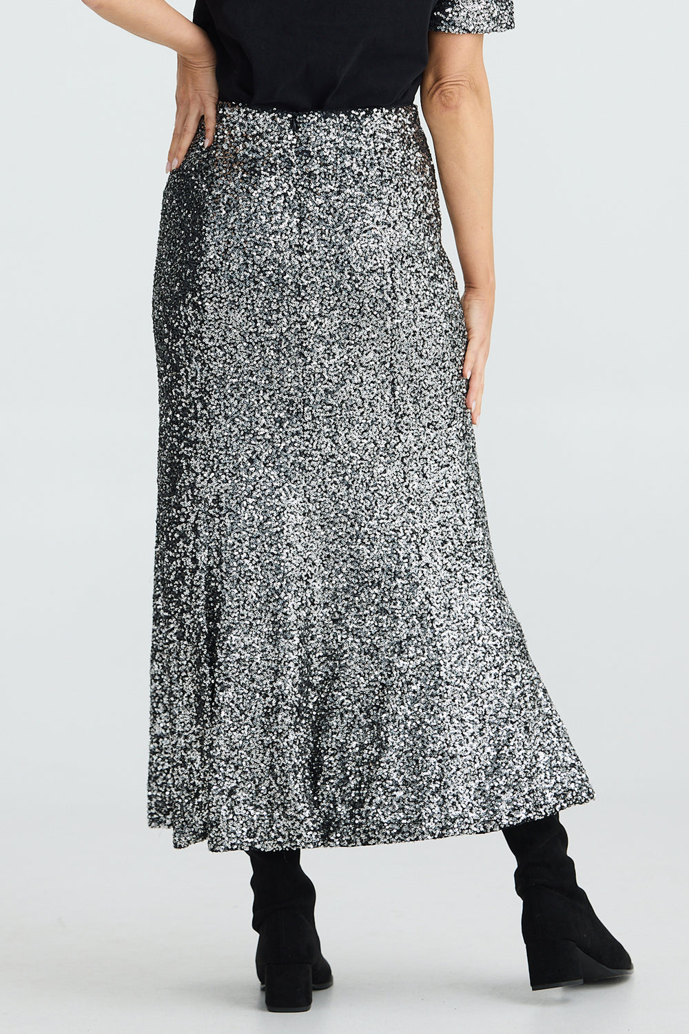 Person wearing a black and white patterned skirt on a white background