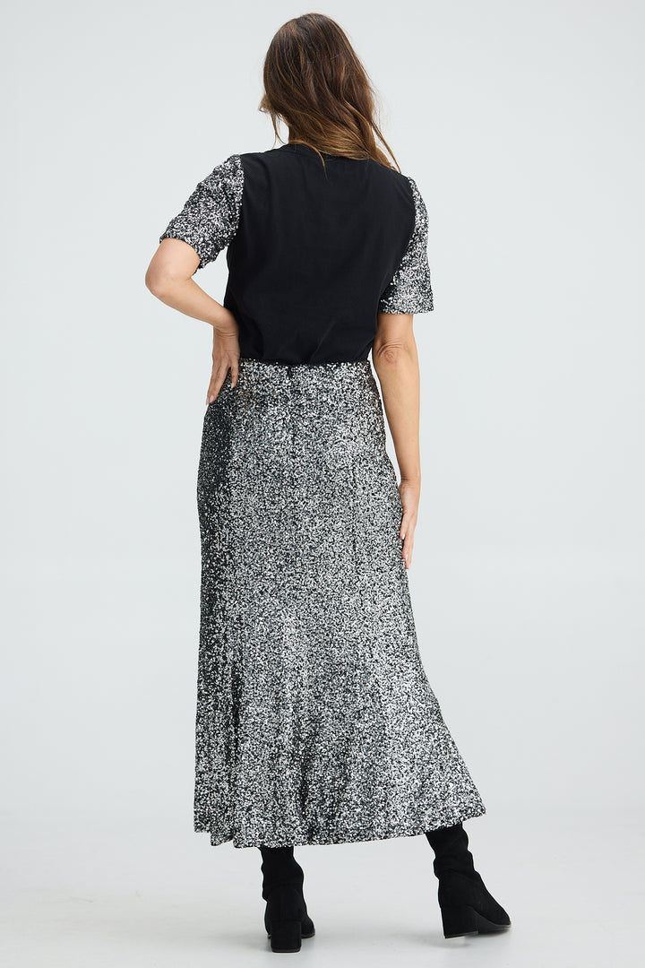 Woman wearing a black and white patterned dress on a white background