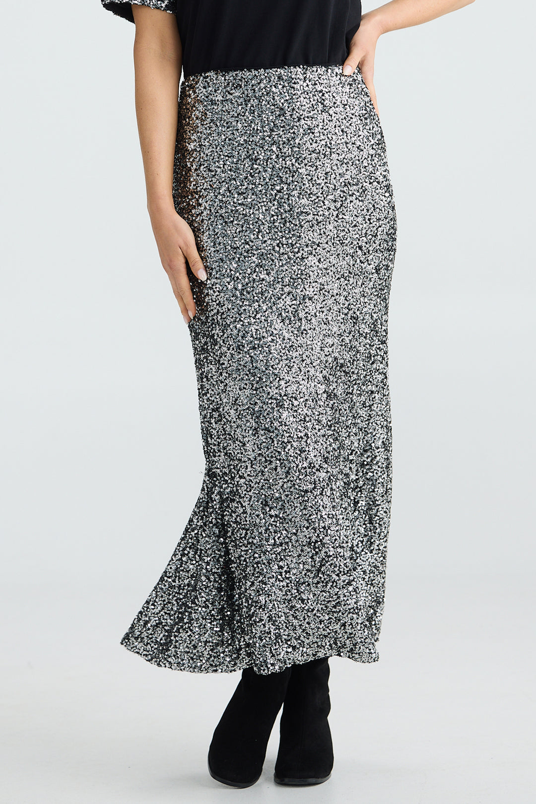 Person wearing a black and white patterned skirt on a plain background