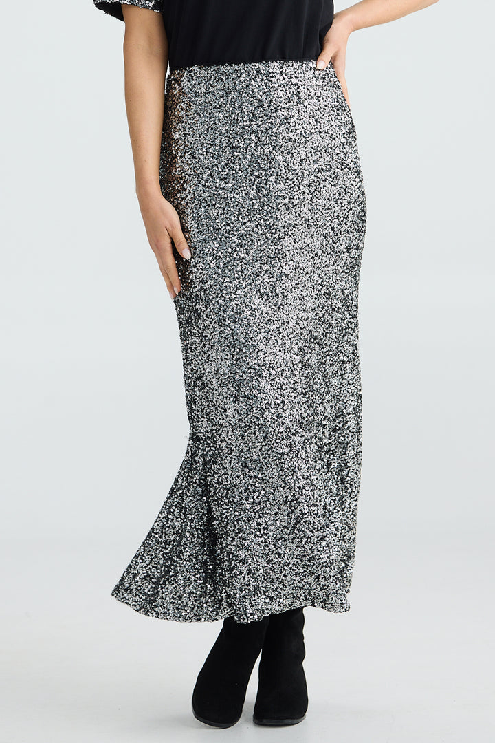 Person wearing a black and white patterned skirt on a plain background