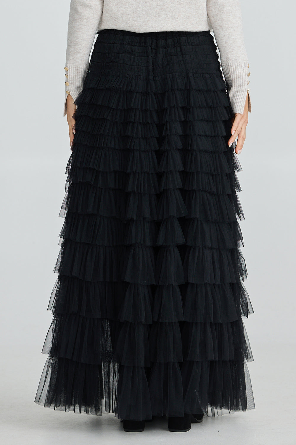 Black tiered skirt worn by a person on a white background