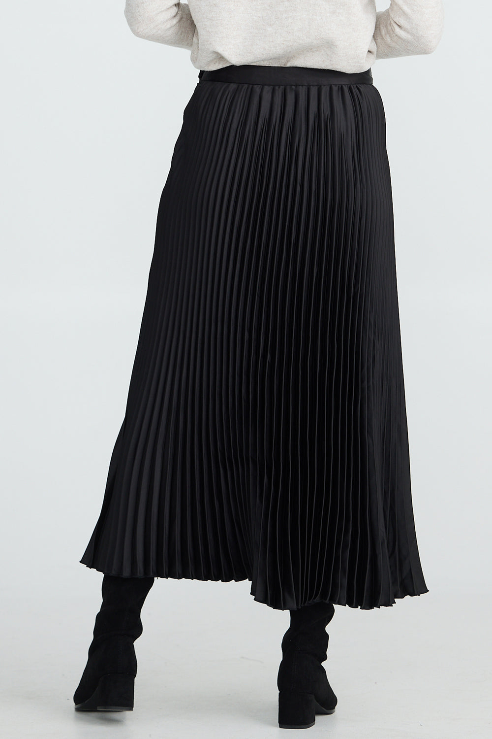 Person wearing a black pleated skirt on a white background