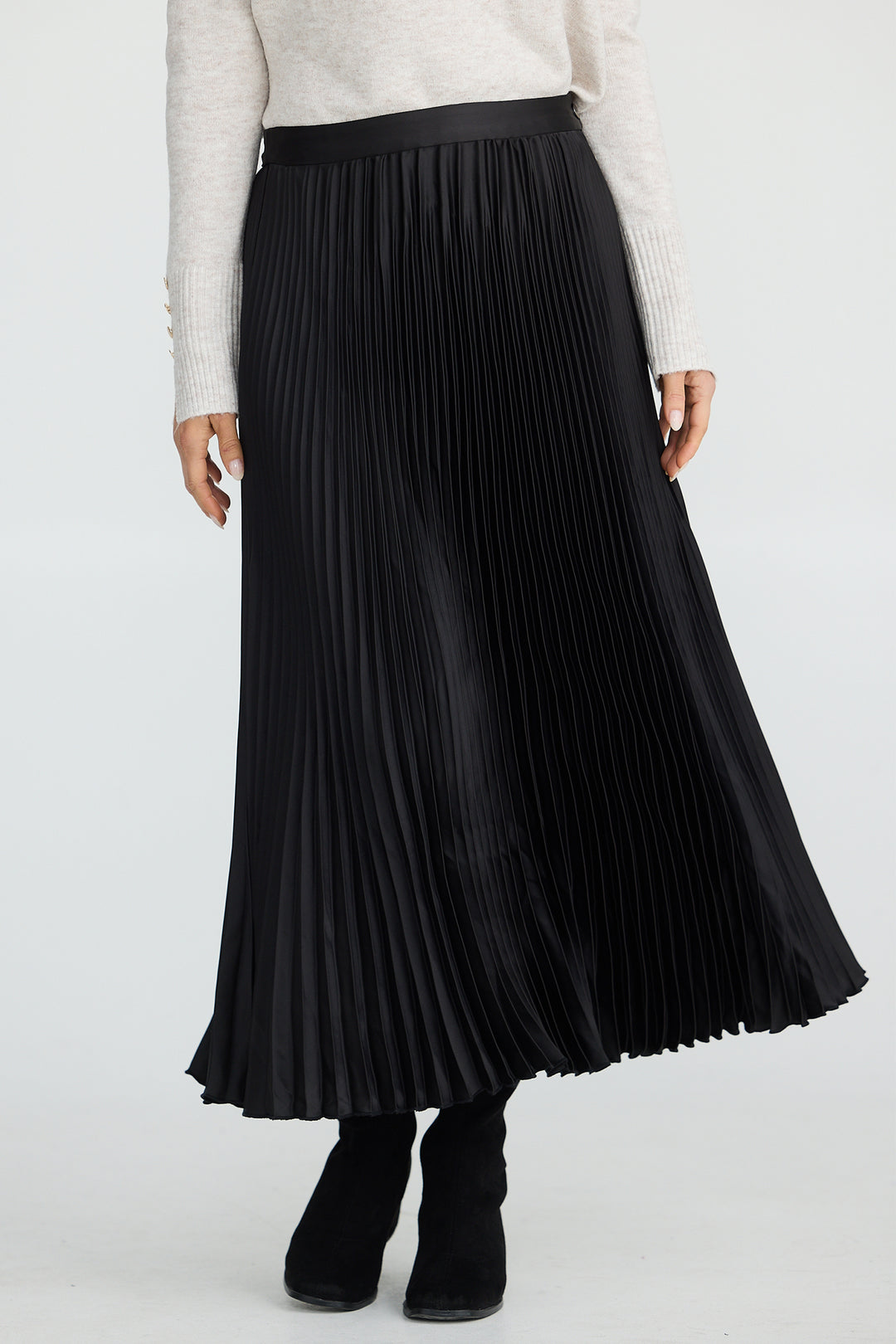 Person wearing a black pleated skirt and white top on a white background