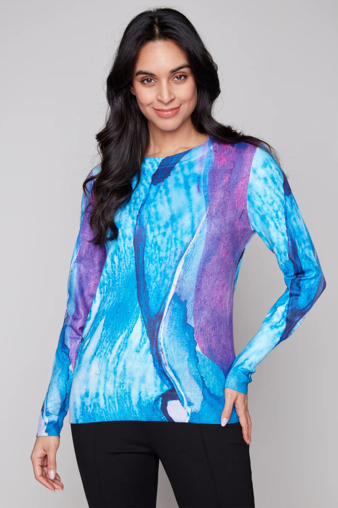 Woman wearing a blue and purple patterned top against a gray background