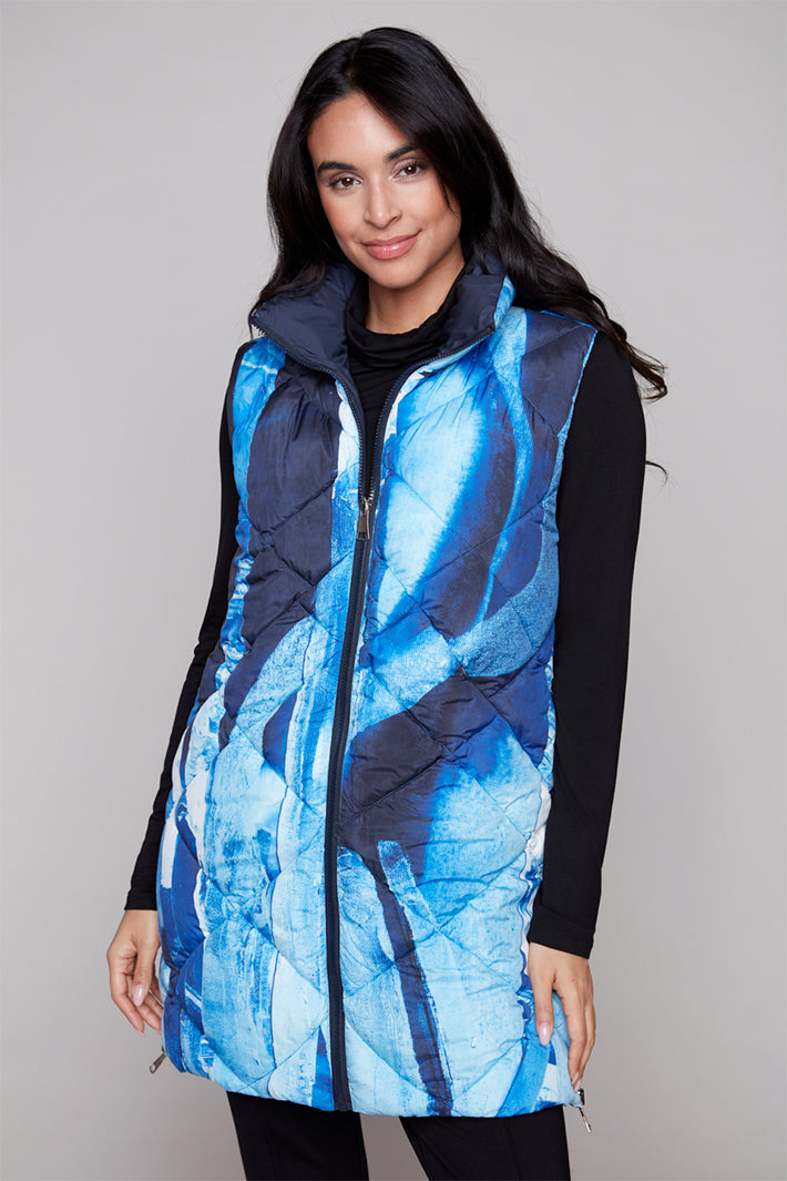 Woman wearing a blue and black patterned vest against a plain background