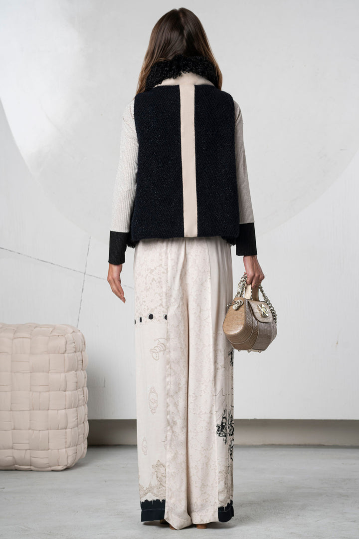 Woman wearing a black and beige outfit with a white background