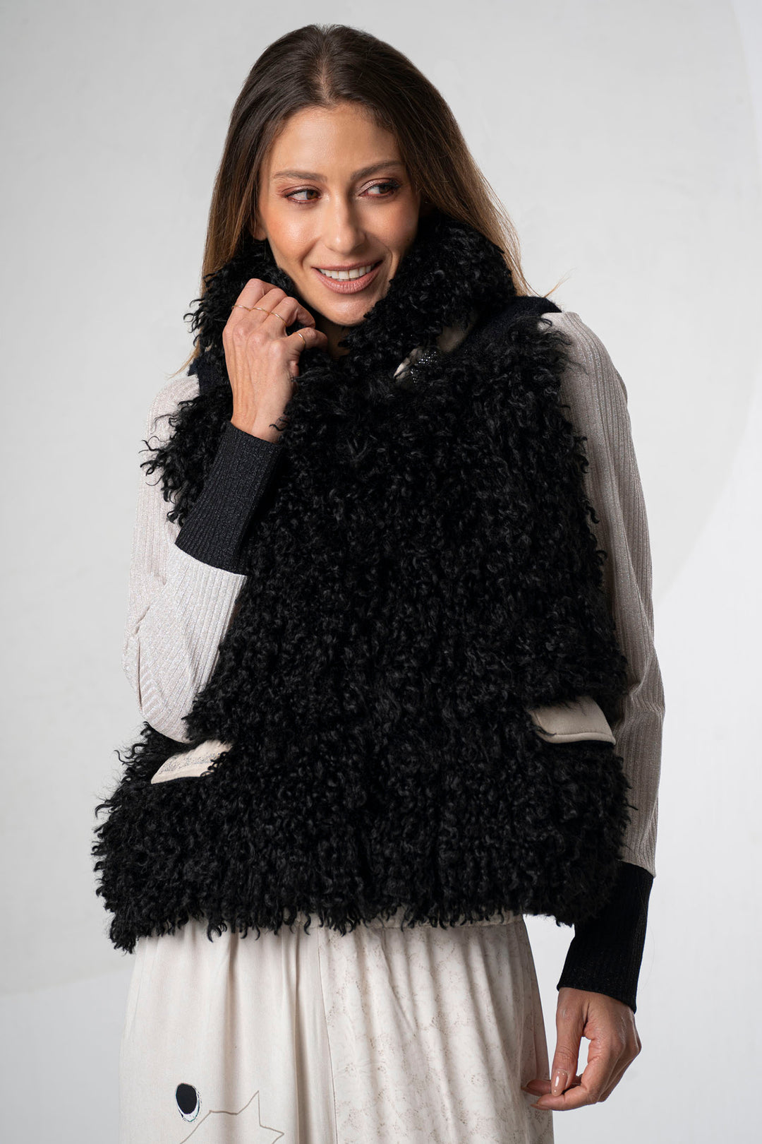 Woman wearing a black fluffy vest against a white background