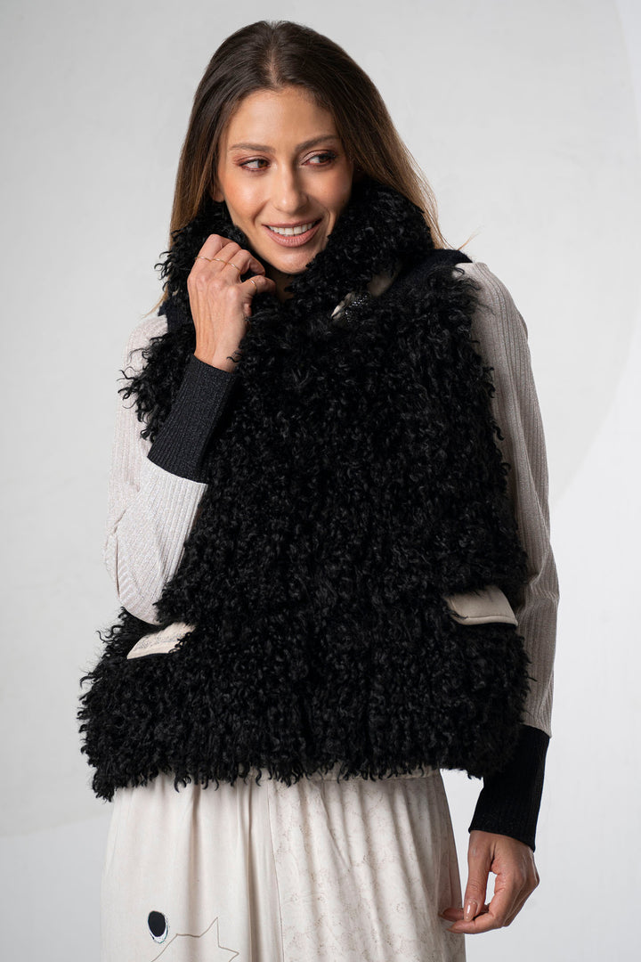 Woman wearing a black fluffy vest against a white background