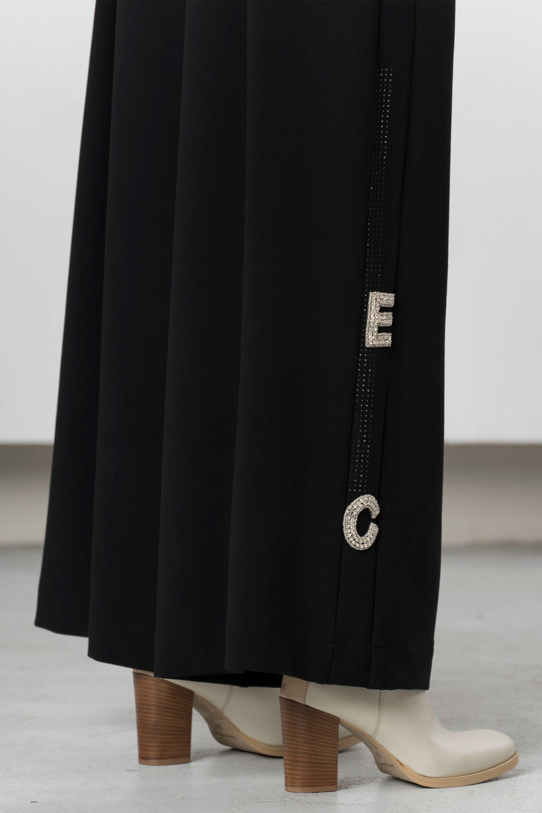 Black Trousers with 'EC' embroidery on a white background