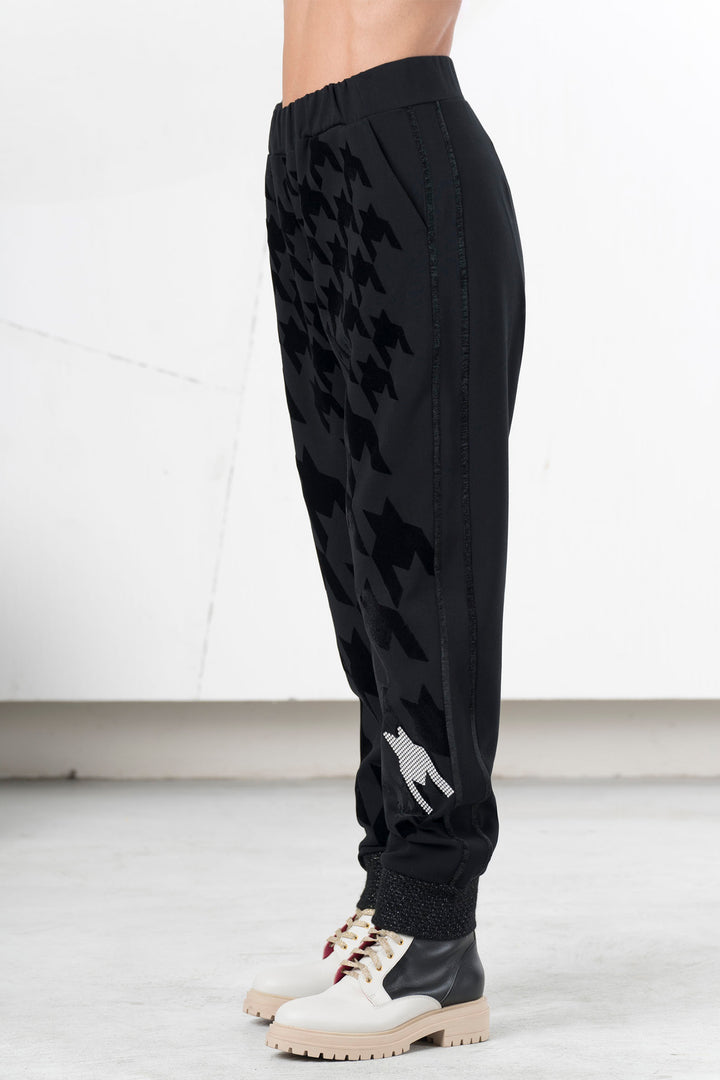 Black jogger pants with a small white graphic on a white background