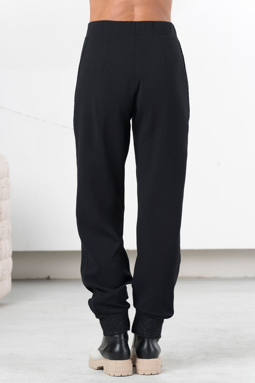 Person wearing black pants with a white background