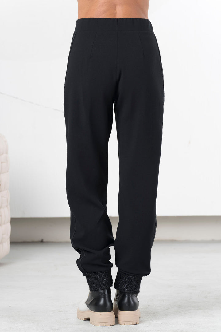 Person wearing black pants with a white background