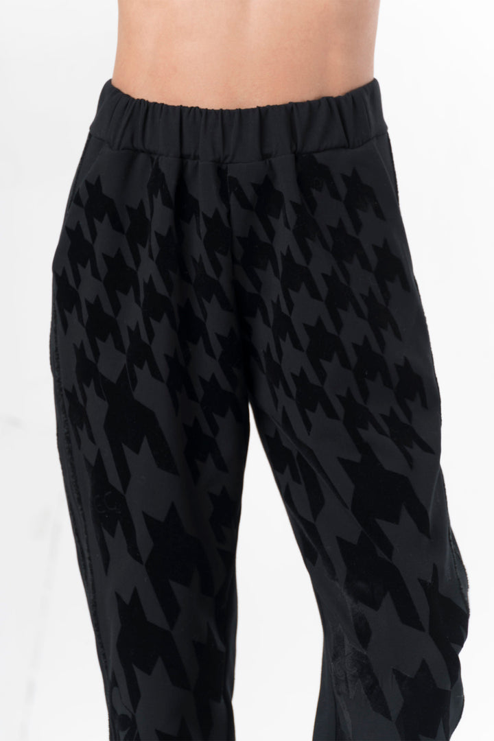 Black houndstooth patterned pants on a white background