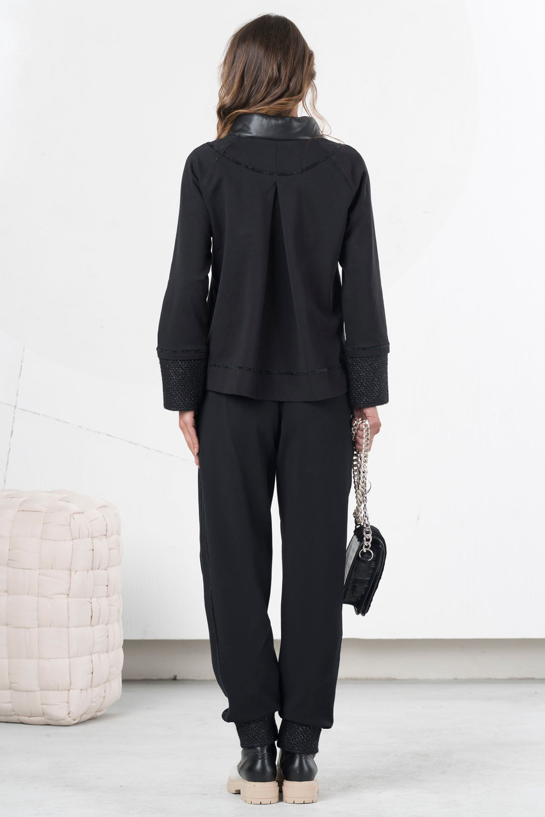 Person wearing a black outfit with a white background