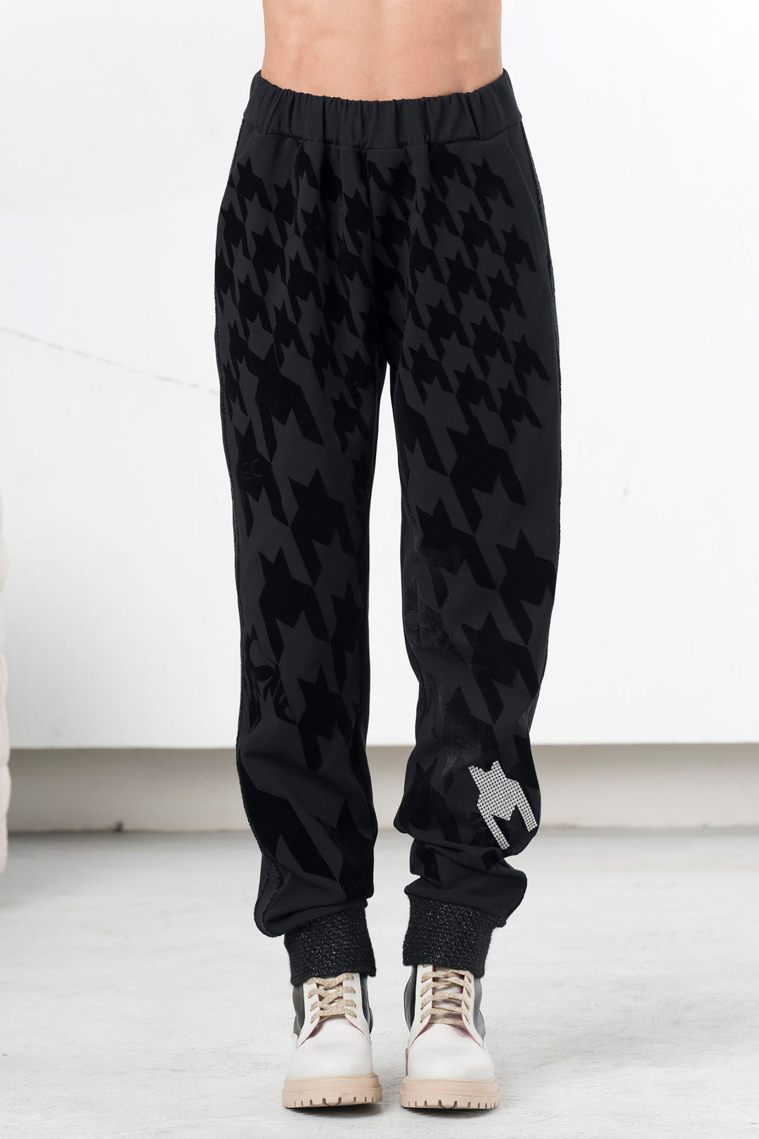 Black patterned jogger pants worn by a person on a white background
