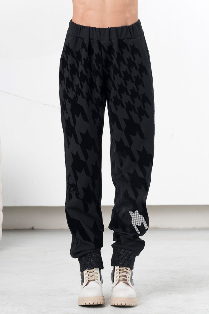 Black patterned jogger pants worn by a person on a white background