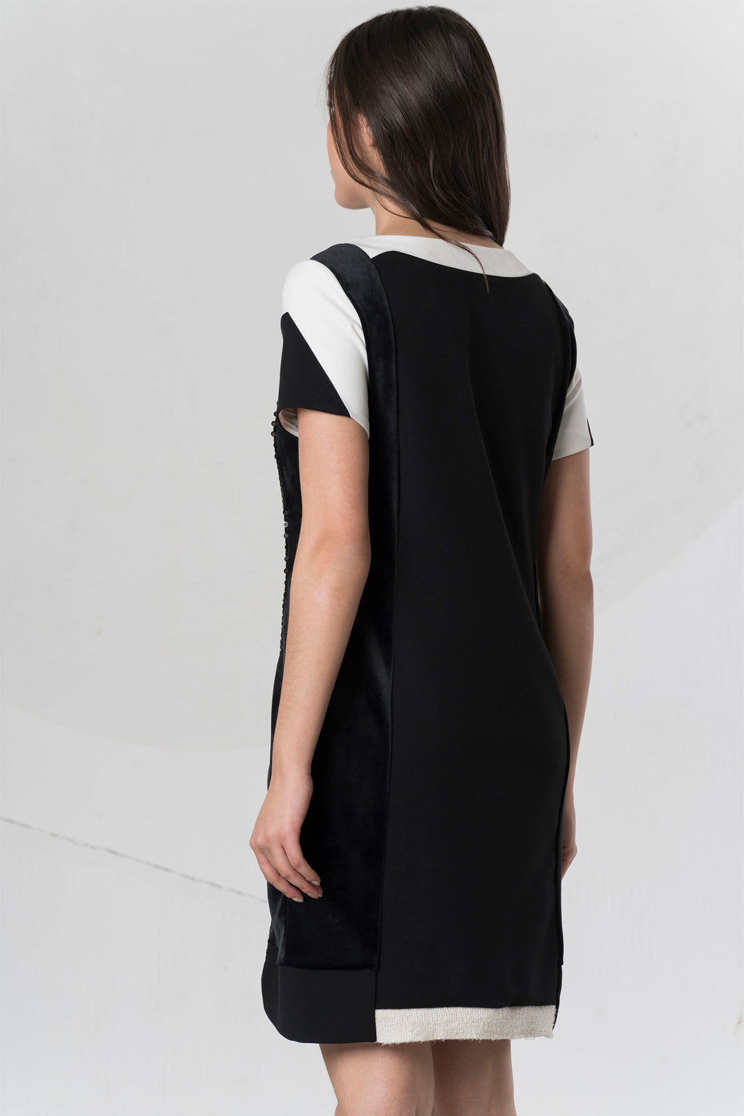 Woman wearing a black and white dress on a plain background