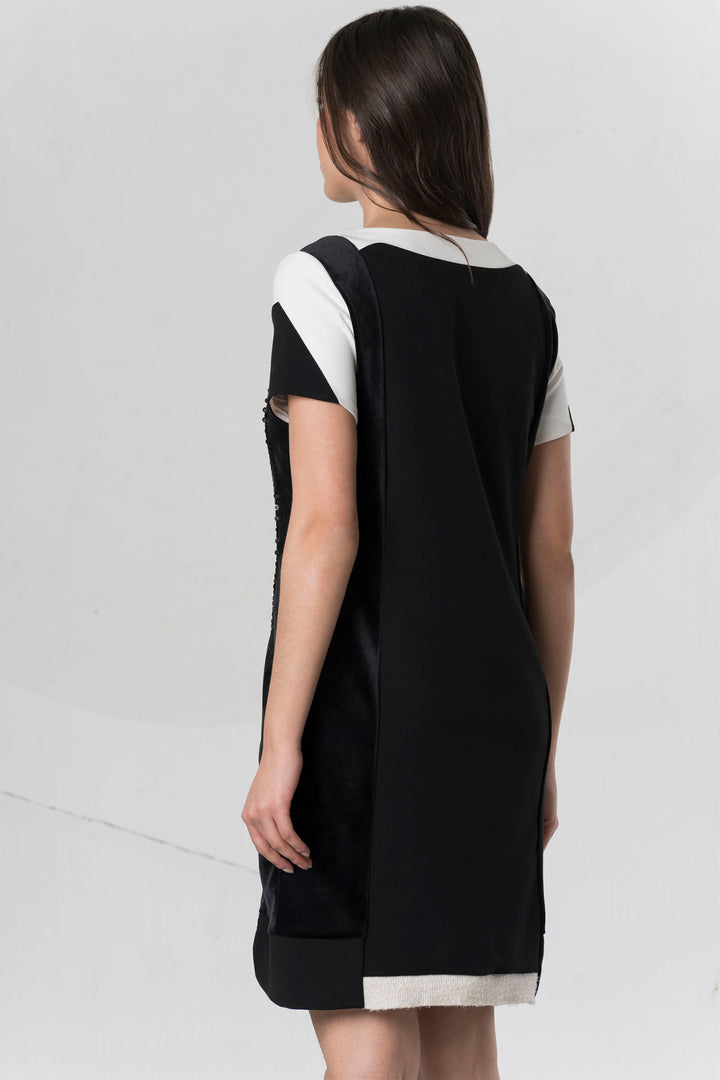 Woman wearing a black and white dress on a plain background