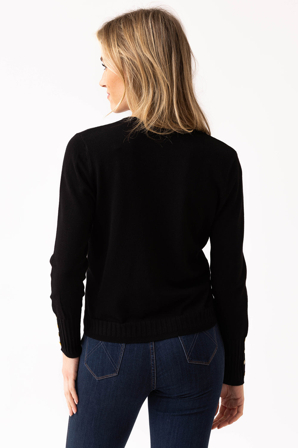 Person wearing a black sweater and blue jeans on a white background