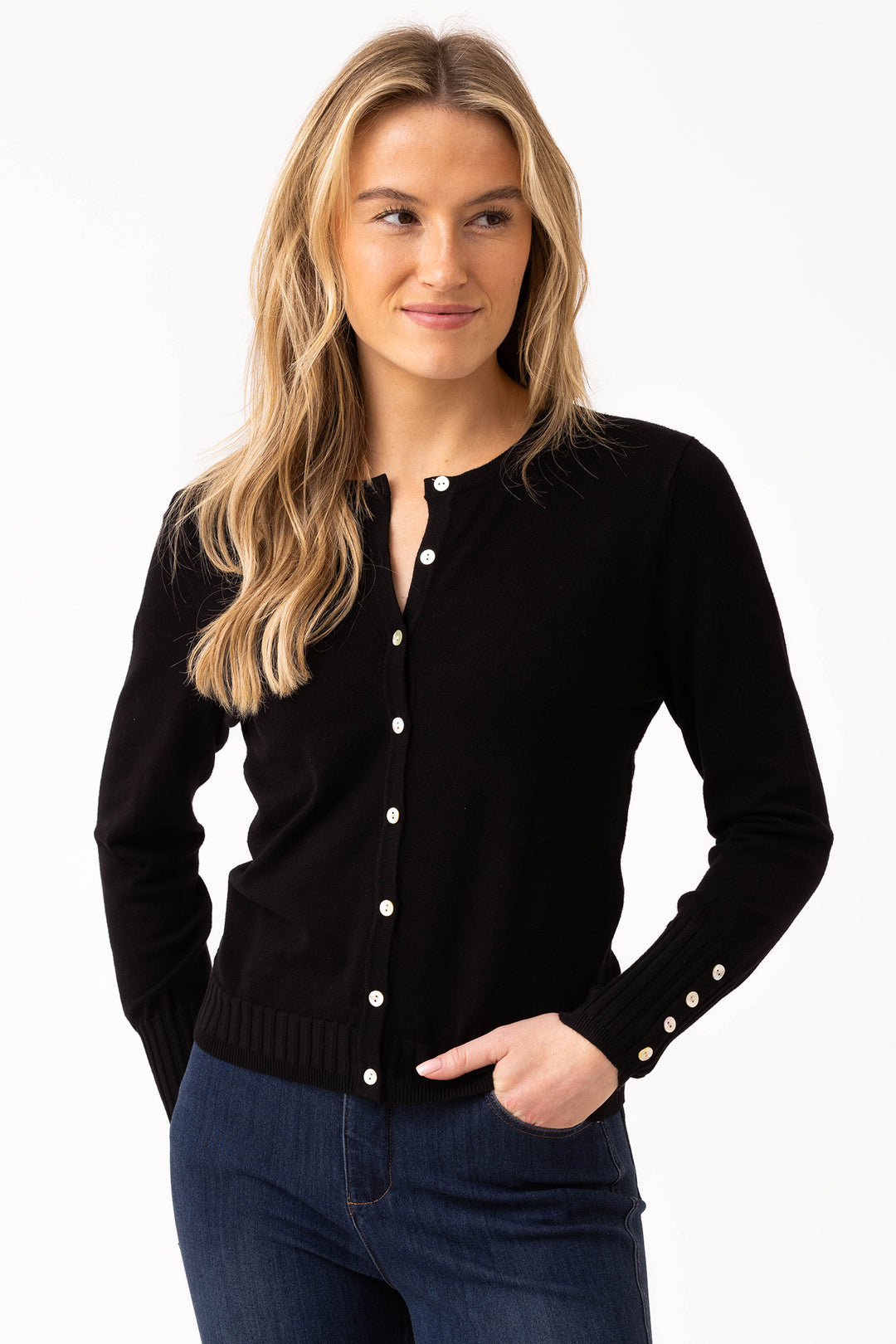 Woman wearing a black cardigan with white buttons on a white background
