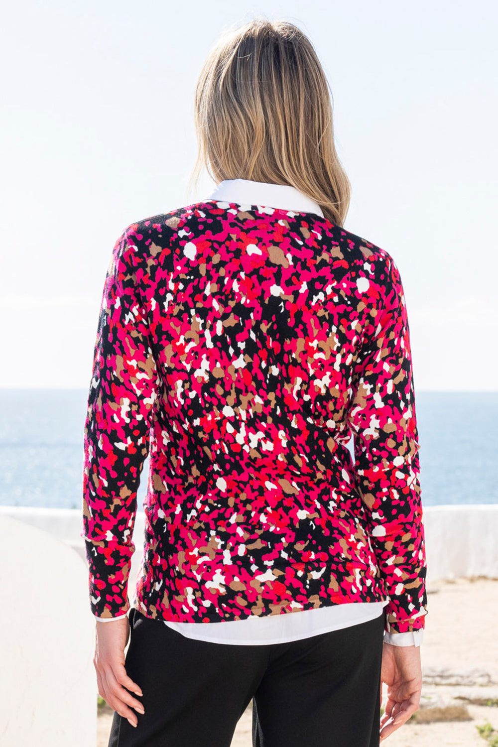 Person wearing a colourful patterned jumper with a blurred background