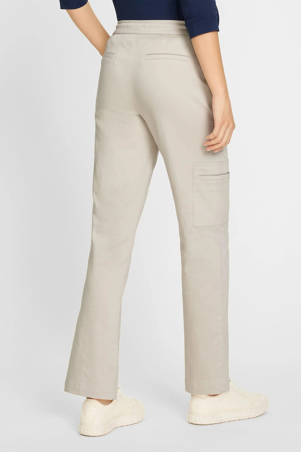 Beige pants worn by a person on a white background