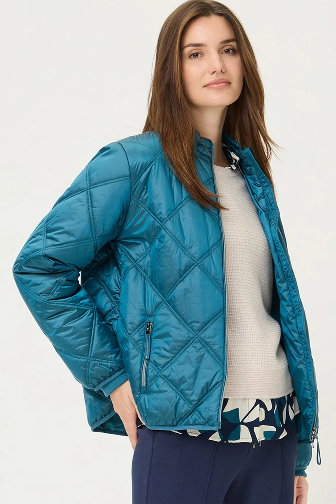 Woman wearing a blue quilted jacket on a white background