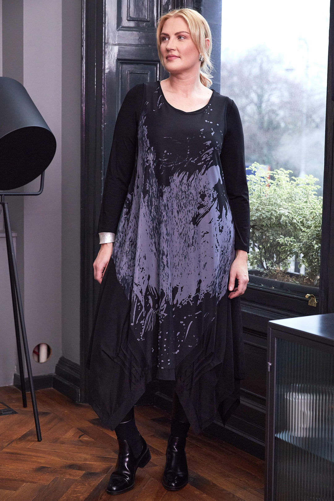 Woman wearing a black and gray dress with a sequin overlay in an indoor setting.