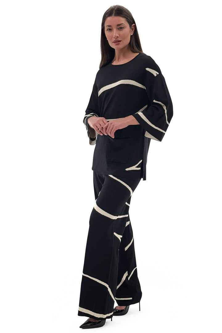 Woman wearing a black outfit with white accents on a white background