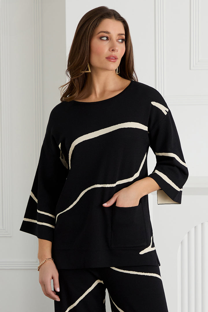 Woman wearing a black sweater with white stripes against a white wall.