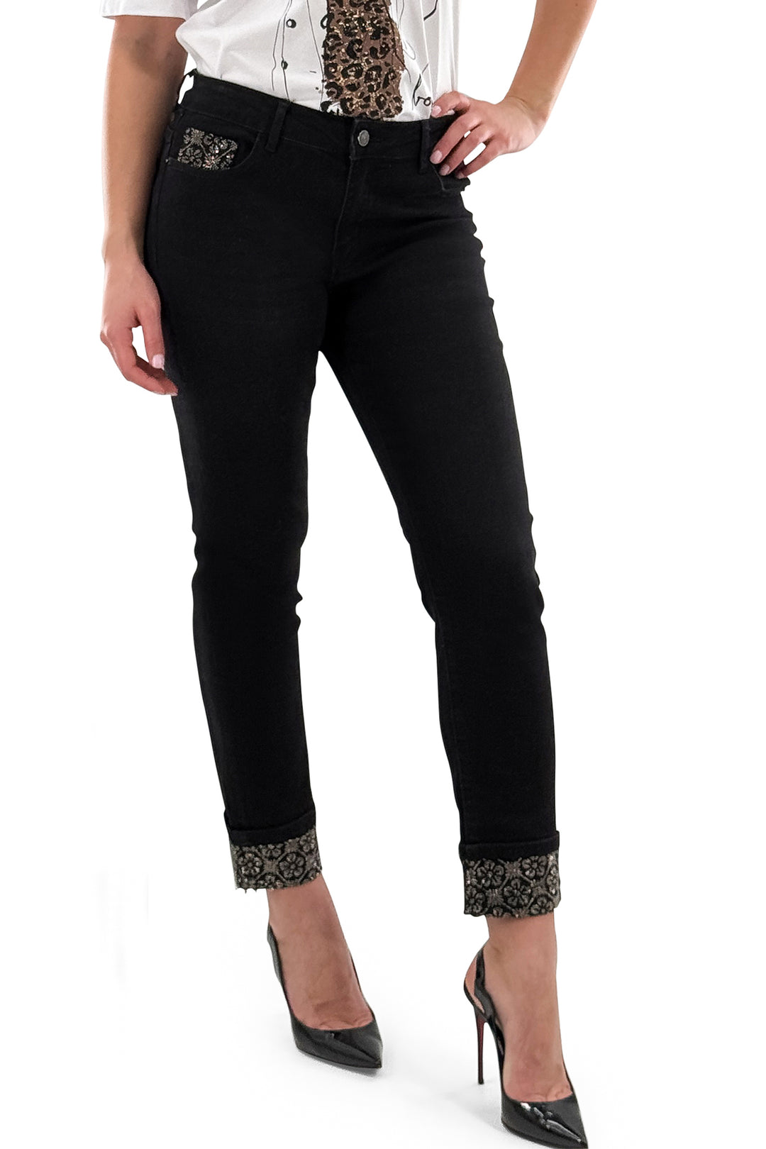 Black jeans with decorative cuffs worn by a person on a white background