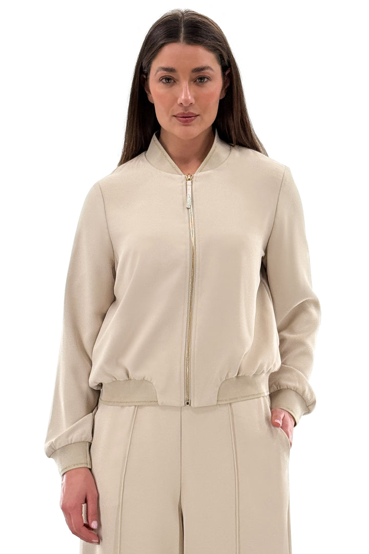Woman wearing a beige tracksuit on a white background