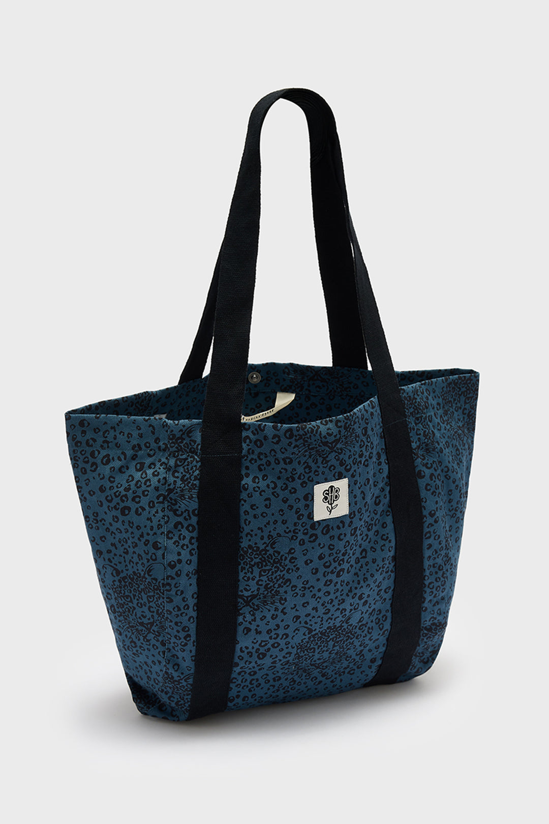 Blue tote bag with black straps on a white background