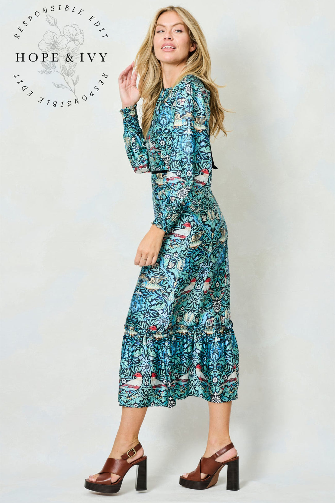 Woman wearing a floral dress with 'Hope & Ivy' branding on a white background