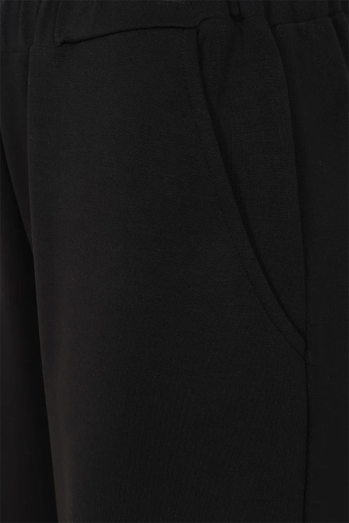 Close-up of black pants with a focus on texture and fit.