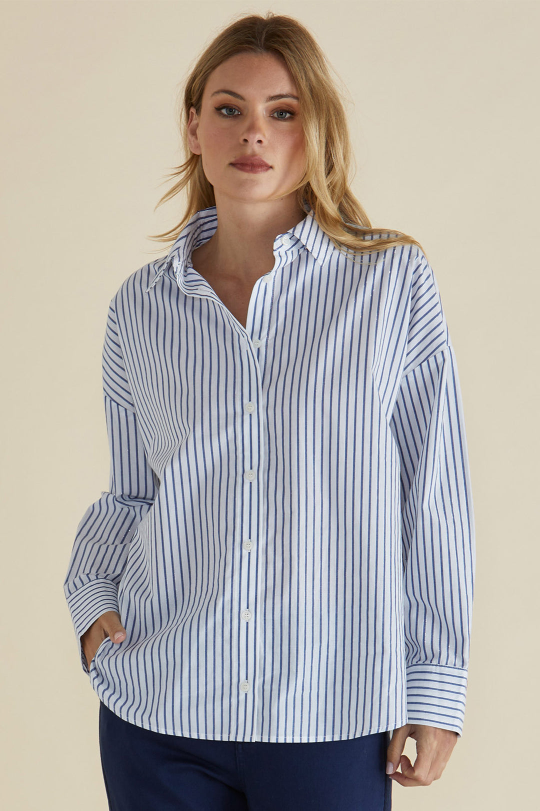 Woman wearing a blue and white striped shirt against a beige background