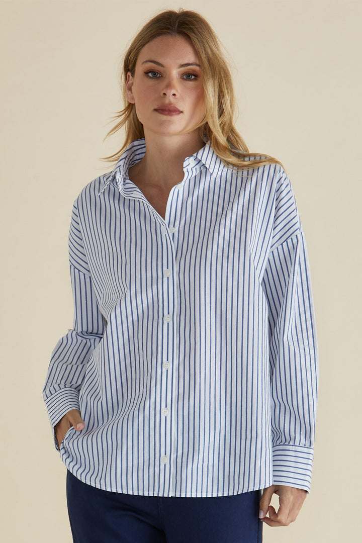 Woman wearing a blue and white striped shirt against a beige background