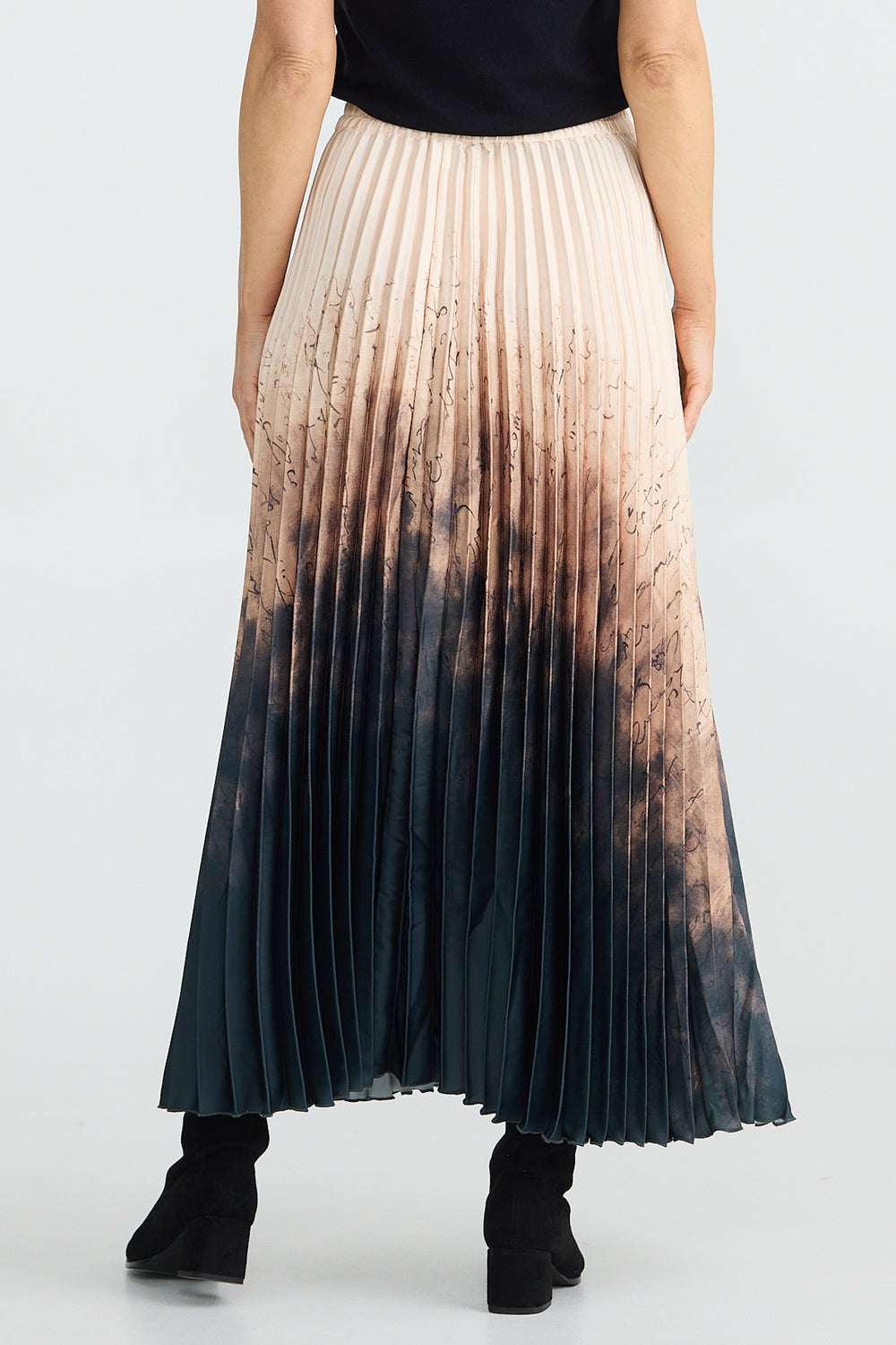 Person wearing a pleated skirt with a gradient pattern on a white background