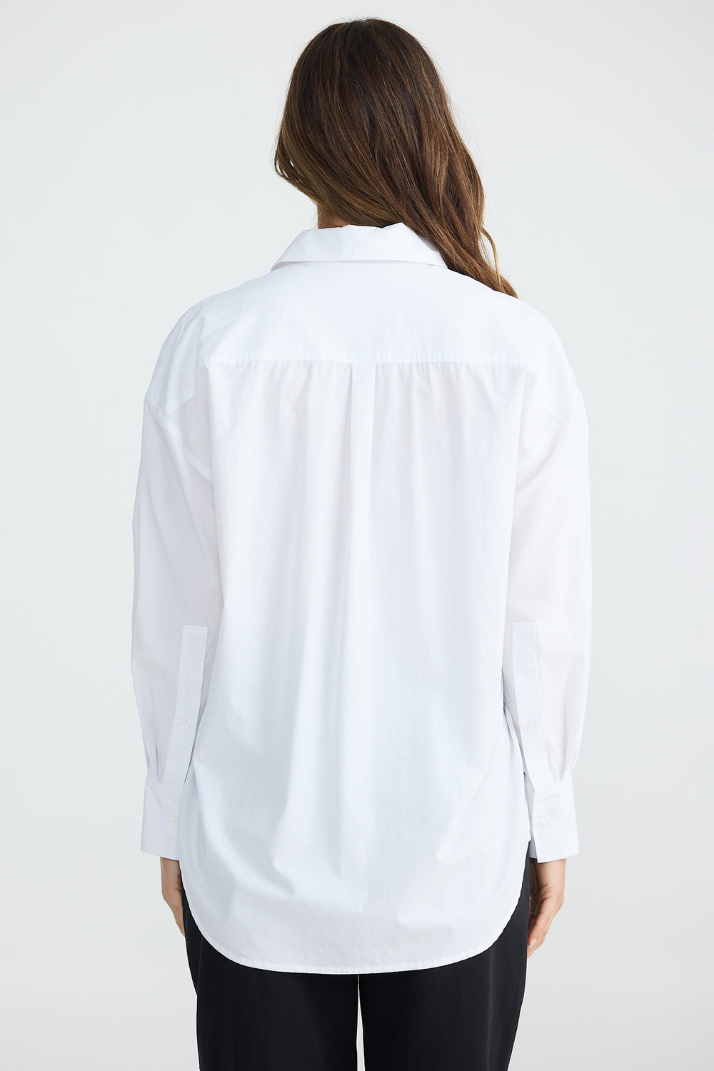 Person wearing a white shirt on a plain background