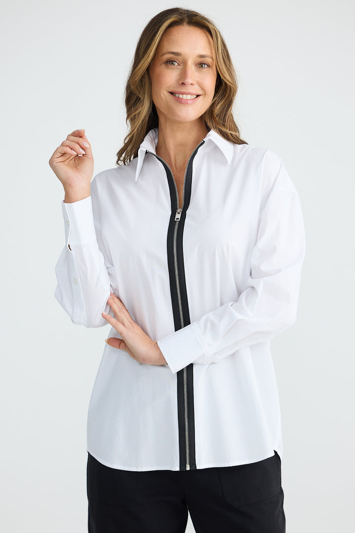 Woman wearing a white shirt with a black zipper on a white background