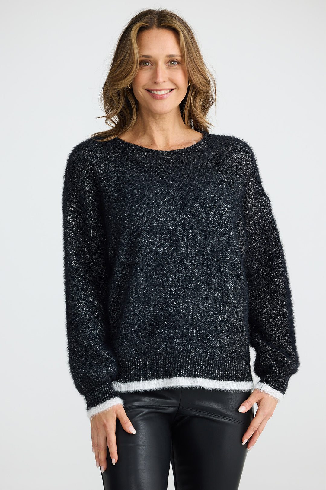 Woman wearing a dark gray sweater with white trim on a plain background