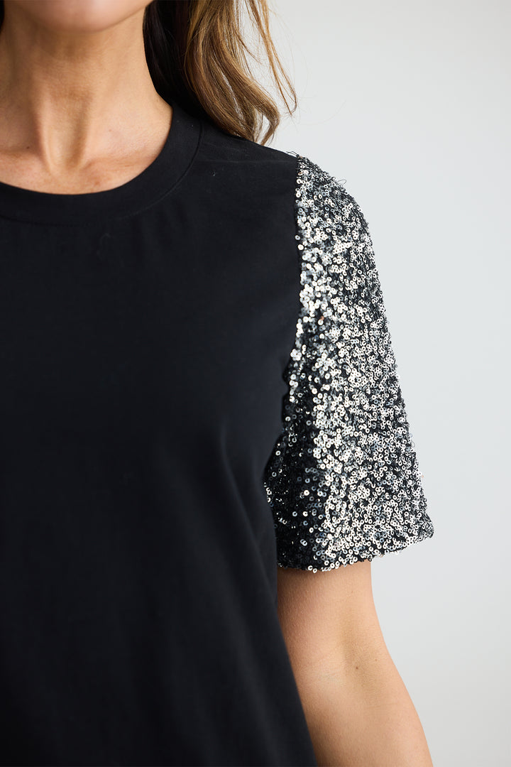 Black dress with sequin sleeves on a plain background