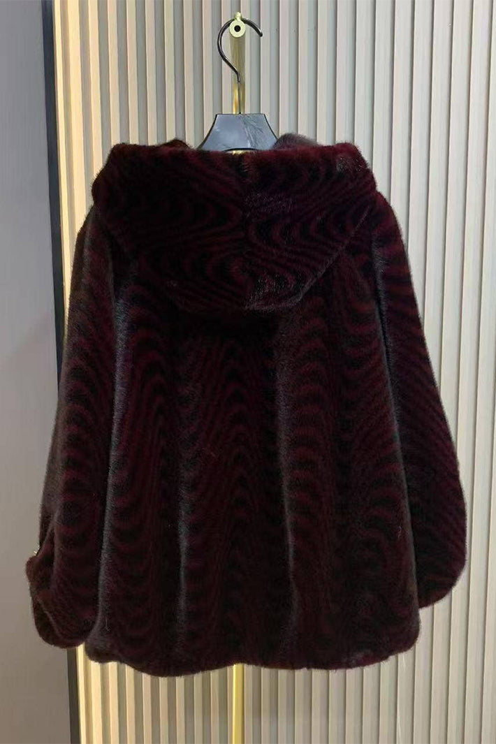 Dark brown fur coat on a hanger against a striped background