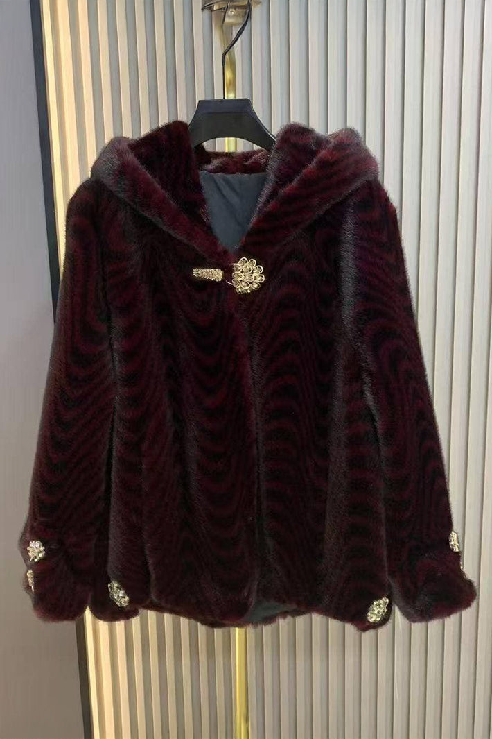 Maroon faux fur jacket with gold buttons on a hanger against a striped background