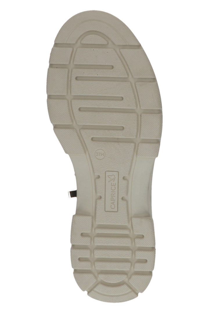 Close-up of a beige shoe sole with brand logo on a white background