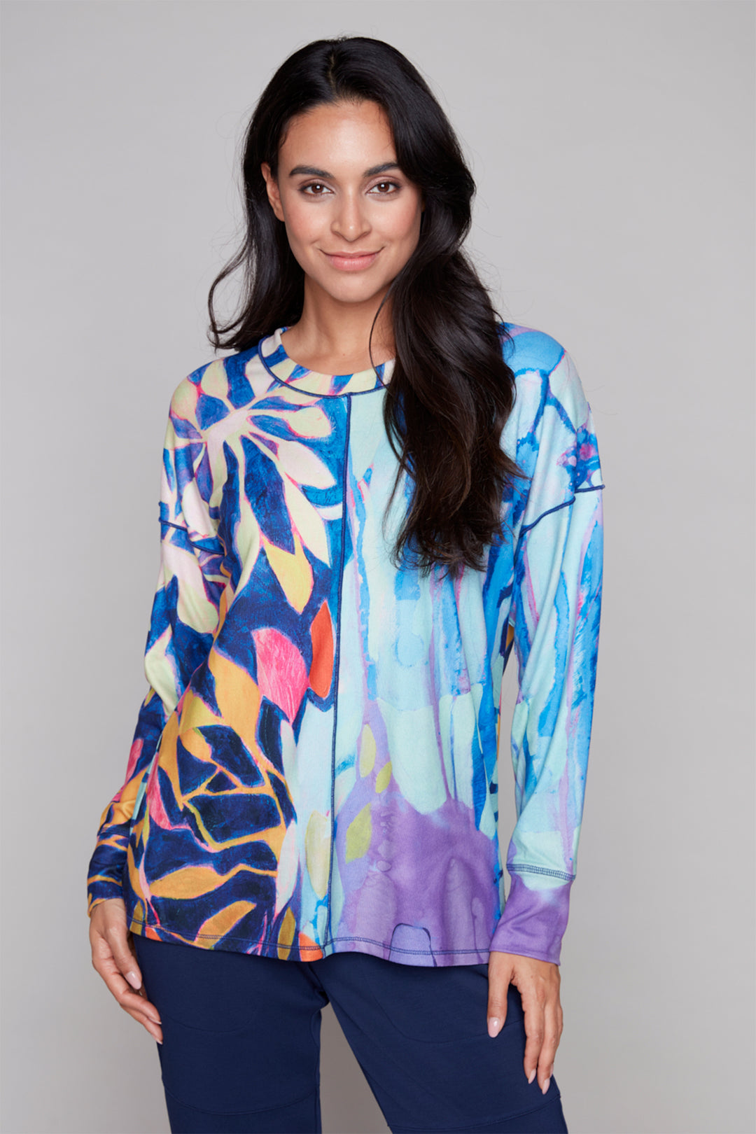 Woman wearing a colorful abstract patterned top against a gray background