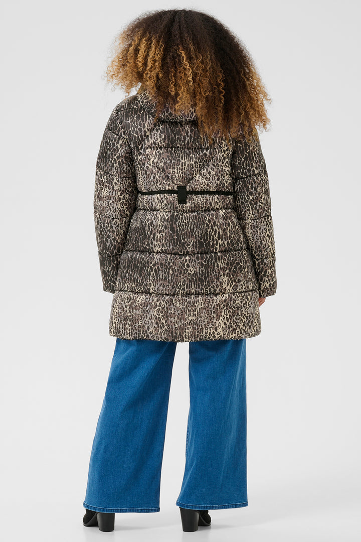 Person wearing a patterned coat and blue pants on a white background