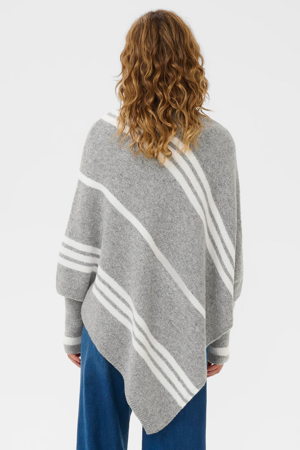 Person wearing a gray poncho with white stripes from behind on a light gray background