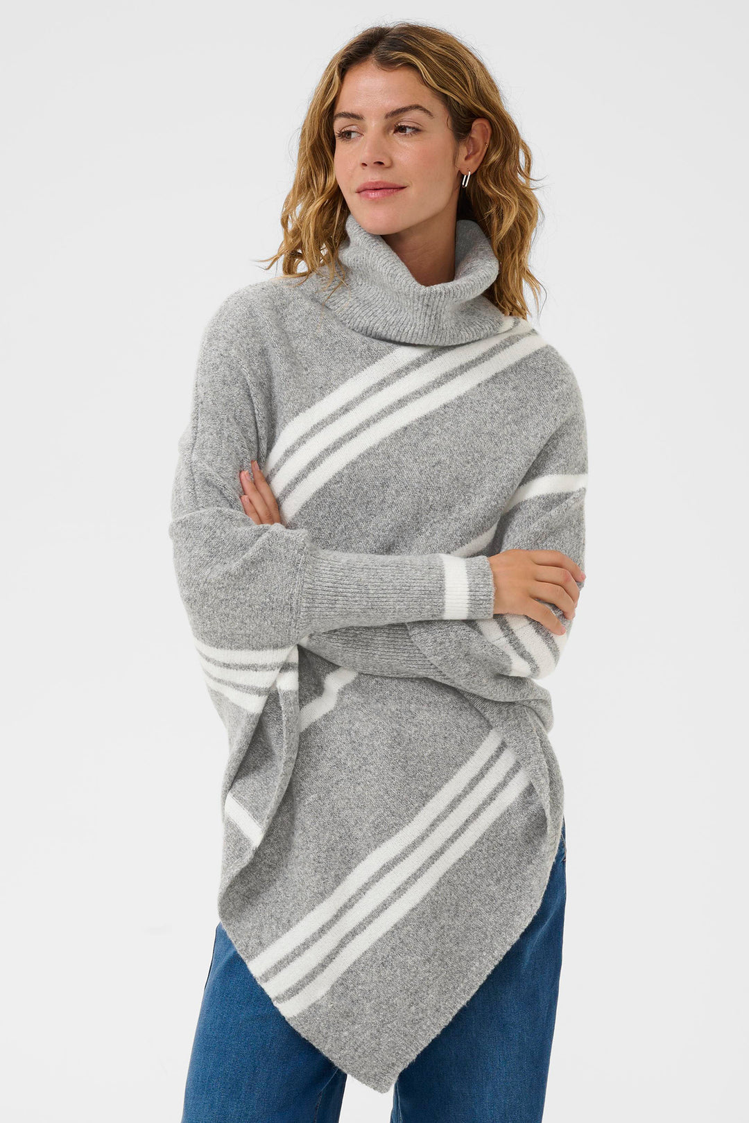 Woman wearing a gray poncho with white stripes on a light gray background