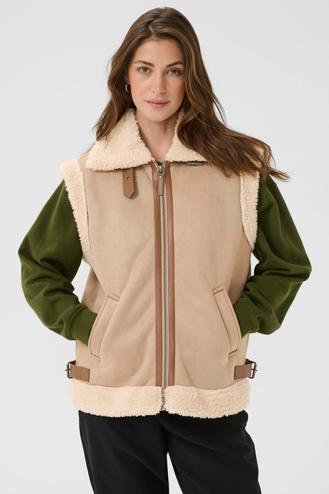 Woman wearing a beige and green jacket with a white background